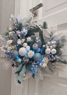 a wreath with blue and white ornaments hanging on a door