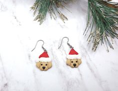 a pair of earrings with a bear wearing a santa hat