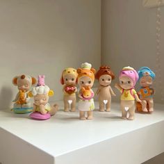 a group of toy figurines sitting on top of a white table next to each other