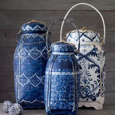 three blue and white vases sitting next to each other on a wooden table,