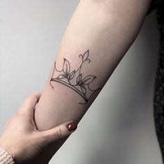 a woman's arm with a flower tattoo on the left side of her arm