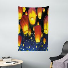 a wall hanging in a living room with many lit up lanterns on the night sky