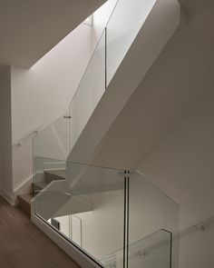 an empty staircase with glass railings leading up to the second floor