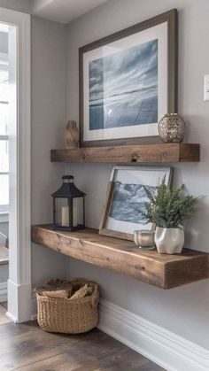 a wooden shelf with two pictures on it next to a basket and lantern in the corner