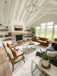 a living room filled with furniture and a fire place in front of a large window