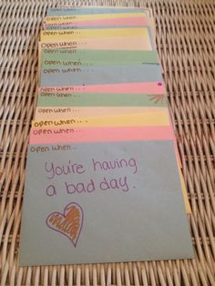 a stack of note cards sitting on top of a wicker table next to a cell phone