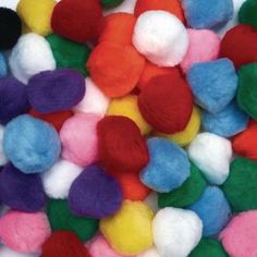 multicolored wool pom poms are scattered on top of eachother