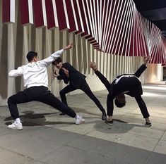 three young men are doing tricks on the sidewalk