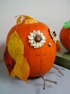 two pumpkins are decorated with leaves and flowers