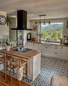 a kitchen with an island counter and stools in front of the stove top oven