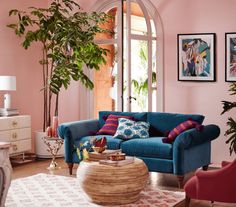 a living room with pink walls and blue couches