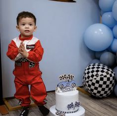 a young boy standing in front of a cake