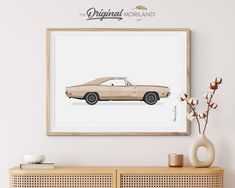 an art print of a brown car on a white wall next to a vase with flowers