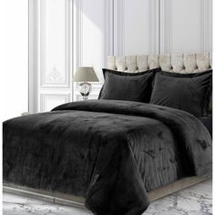 a black comforter set on a bed in a room with white walls and marble flooring