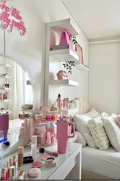 a room filled with lots of pink items on top of a white table next to a mirror