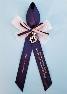 a purple ribbon with a gold cross on it and some ribbons attached to the side