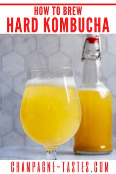 a glass full of beer next to a bottle with the words how to brew hard kombucha