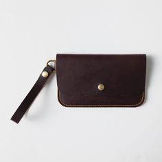 + DIMENSIONS Height: 5.25 inches Width: 8.5 inches Wristlet strap length: 5.5 inches + WRISTLET CLUTCH DETAILS Keep your friends close – and your daily essentials closer. When you need a sleek way to carry the basic necessities, you can't go wrong with KMM & Co.'s leather wristlet clutch. Handmade in the same full-grain leathers as your favorite tote, the wristlet has space for your cards, keys, and phone. Each wristlet clutch features an undivided main compartment, plus a rear pocket that you c Basic Necessities, Ladies Wallet, Leather Tote Bags, Wallet For Women, Leather Clutch Bag, Small Crosses, Wristlet Clutch, Leather Clutch Bags, Tote Bag Leather