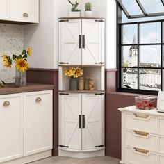 a kitchen with white cabinets and sunflowers in vases