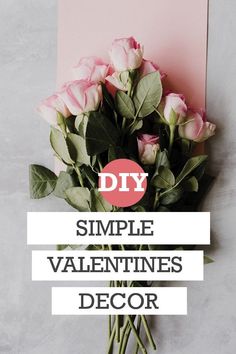 a bouquet of roses sitting on top of a table next to a pink card with the words diy simple valentine's decor