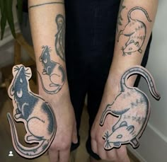 two people with tattoos on their arms holding up small mouse and gerbil stickers