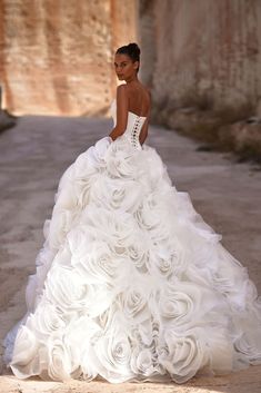 a woman in a white wedding dress standing on the street