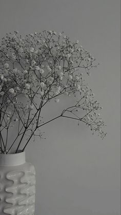 a white vase filled with flowers on top of a table