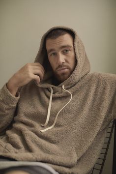 a man with a hoodie on sitting down