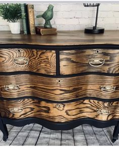 an old dresser has been painted black and gold with woodgrains on the drawers