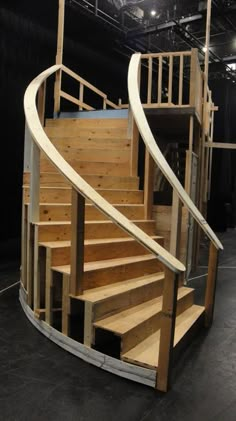 there is a spiral staircase in the middle of a building with wooden steps and railings