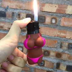 a person holding a lighter in their hand with a pink bra on it's chest