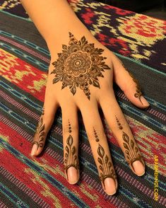 a woman's hand with henna tattoos on it