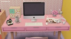 a pink desk with a computer, phone and other items on it