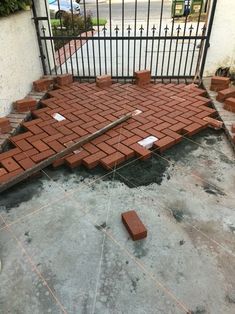 a brick walkway is being built in front of a gate