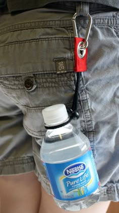 a person wearing shorts with a bottle of water in his pocket on the belt that is attached to their waist