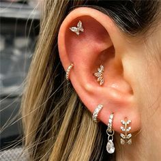 a close up of a person's ear with three different types of earrings on it