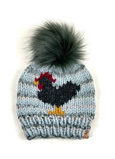 This is a super cute Chicken Beanie, hand knit out of Lion Brand Wool Ease Super Bulky yarn in Arctic Ice with a 6" Graphite faux fur pom pom that is detachable.This is an adult women's size and measures approximately 9" in length, not including the pom.The hat can be washed, I recommend hand wash. lay flat to dry. The pom is not washable and is attached with a button that makes it super secure but also very easy to remove. The yarn is 20% wool 80% acrylic Ready to ship Chicken Hats, Arctic Ice, Cute Chicken, Lion Brand Wool Ease, Cute Chickens, Super Bulky Yarn, Super Bulky, Wool Beanie, Faux Fur Pom Pom