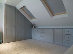 an attic bedroom storage room with drawers and cupboards