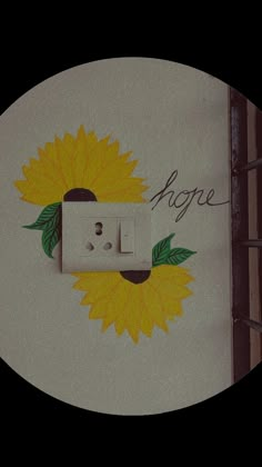 a sunflower painted on the side of a wall next to a light switch cover