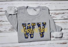 Customized West Virginia City Sweatshirt. This Gildan 18000 unisex sweatshirt will be made with navy blue West virginia paisley fabric for the applique and  matching thread. The city name is stitched across the applique in yellow gold thread. Font size will vary depending on the amount of letters in the name.  Enter no persoanlization if you are not wanting it.   Perfect for everyone with West Virginia Pride!   Great for football weather!  All sweatshirts are made to order.   Fabric placement may vary from picture. ▸ Gildan 18000 brand medium heavy sweatshirt made with 50% cotton & 50% polyester ▸ Unisex Adult Sizing - runs true to size. Please see photo for sizing. ▸ Rolled Sleeves in pictures is for styling purposes only Want a different fabric or thread color?  No problem just message u City Sweatshirt, Applique Sweatshirt, Virginia City, Virginia State, Paisley Fabric, Nurse Sweatshirt, Grey Crewneck, Embroidered Crewneck, Mama Sweatshirt