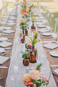 a long table is set with flowers and place settings