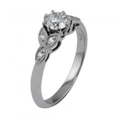 a white gold engagement ring with an oval diamond center and two leaves on the side