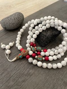 Beautiful Howlite Mala from Nepal and Mountain shell beads Mala necklace. You can choose between the mala that is made with howlite beads (white with gray) and mix metal beads from Nepal, or the all white mala necklace, which is made with mountain shell beads and a yellow mantra symbol. A unique praying mala that can be used as a necklace or as an ornament. The mala has no clasp, you wear it over the head. --The Mala with the metal beads and the red beads has a total length of 48.2cm- 19 inch lo Buddhist Mala, Wiccan Necklace, Yoga Lover Gift, Beads Mala, 108 Mala Beads, Mens Necklace, Red Beads, Yoga Gifts, Skull Necklace