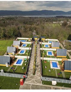 an aerial view of a building with grass on the roof and swimming pool in the middle