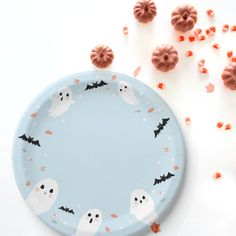 a paper plate decorated with bats and ghost faces on it, surrounded by sprinkles