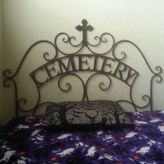 a metal headboard with the word cemetery on it and an iron cross above it