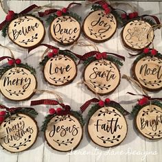 christmas ornaments made out of wood with words on them and red ribbon hanging from the top