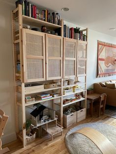 a living room filled with furniture and bookshelves next to a wooden flooring