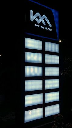 a lit up sign in front of a building at night with the logo water metro on it