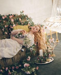 a woman laying on top of a chair covered in flowers